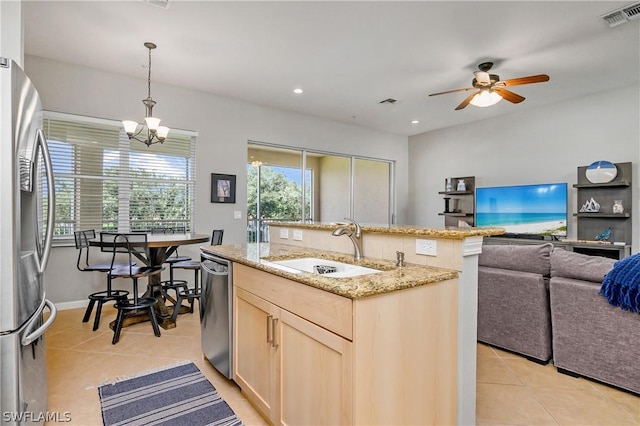 kitchen featuring visible vents, light brown cabinetry, light tile patterned floors, stainless steel appliances, and a sink