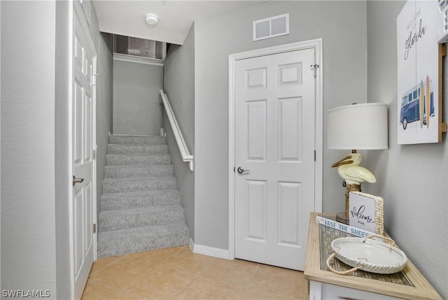 stairway with tile patterned flooring and visible vents