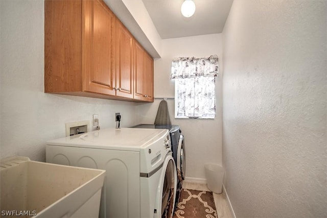 laundry area featuring washer and dryer, sink, and cabinets