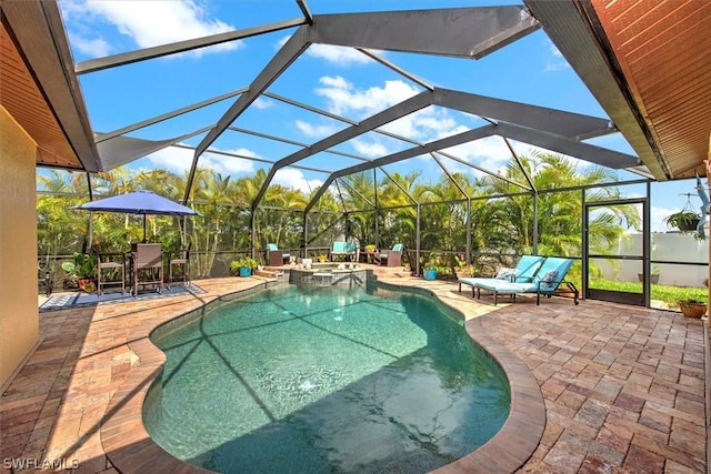 view of swimming pool featuring an in ground hot tub, a patio, and a lanai