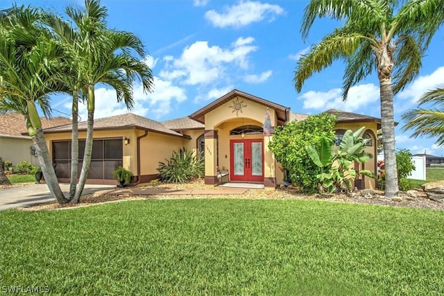 mediterranean / spanish-style house with a front yard and french doors