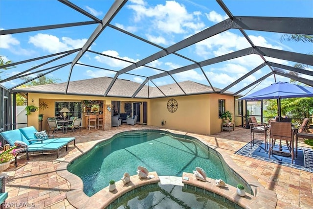 view of pool featuring glass enclosure, an in ground hot tub, outdoor lounge area, and a patio