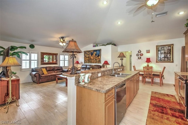 kitchen featuring a center island with sink, sink, vaulted ceiling, stainless steel dishwasher, and light hardwood / wood-style floors