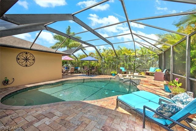 view of pool with glass enclosure, an in ground hot tub, and a patio