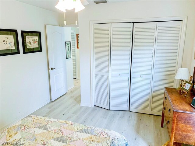 bedroom featuring ceiling fan, a closet, and light hardwood / wood-style flooring