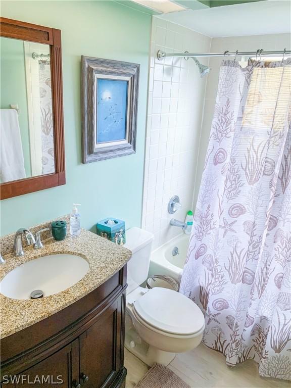 bathroom with toilet, shower / tub combo, and vanity