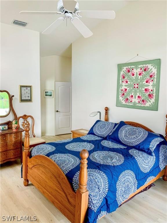 bedroom with wood finished floors, visible vents, and a ceiling fan