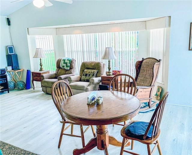 dining space with light wood-type flooring, ceiling fan, and vaulted ceiling