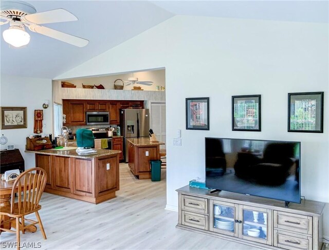 kitchen featuring vaulted ceiling, light hardwood / wood-style flooring, kitchen peninsula, stainless steel appliances, and ceiling fan