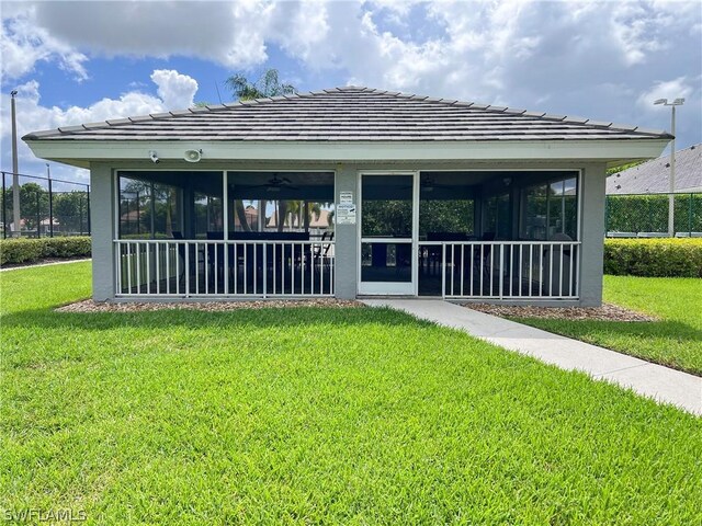 view of front of property with a sunroom and a front lawn