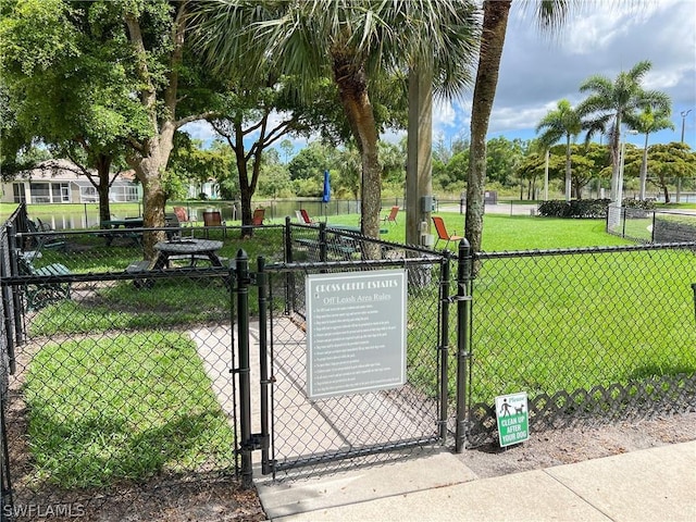 view of gate featuring fence and a yard