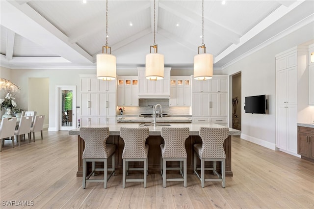 kitchen with a spacious island, light wood-type flooring, and hanging light fixtures