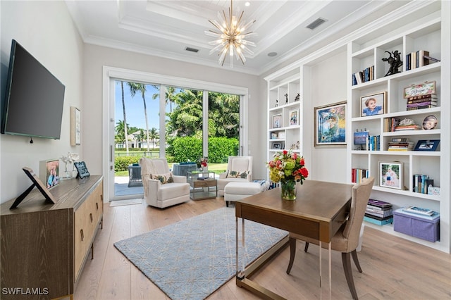 office with crown molding, a chandelier, light wood-type flooring, and built in shelves