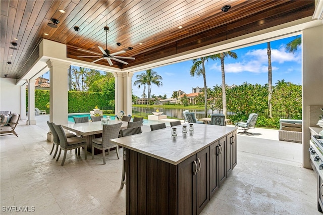 view of patio / terrace featuring a water view and ceiling fan