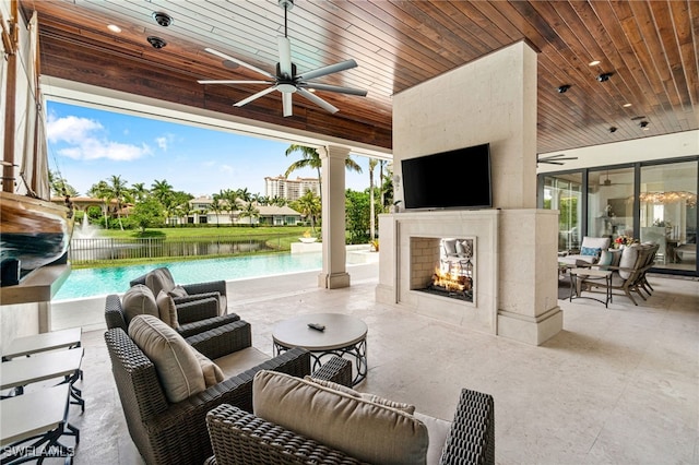 view of patio / terrace with an outdoor living space with a fireplace and ceiling fan