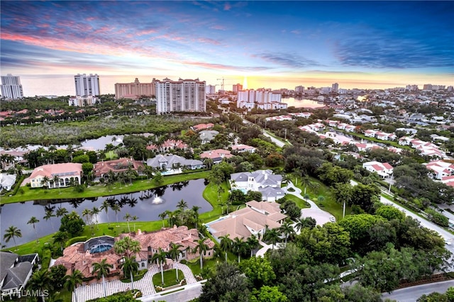 aerial view at dusk featuring a water view