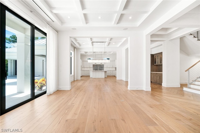 unfurnished living room with light hardwood / wood-style flooring, beamed ceiling, and coffered ceiling