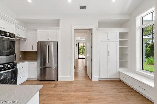 171 N St, Naples, FL 34108 - kitchen with high end fridge, oven, estacked washer and dryer, white cabinetry, and recessed lighting