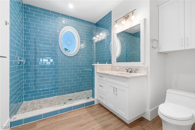 bathroom featuring tiled shower, vanity, and toilet