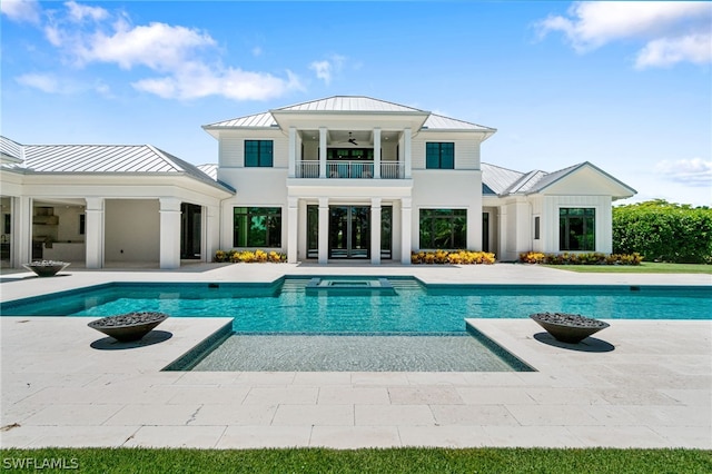 rear view of property with a balcony and ceiling fan