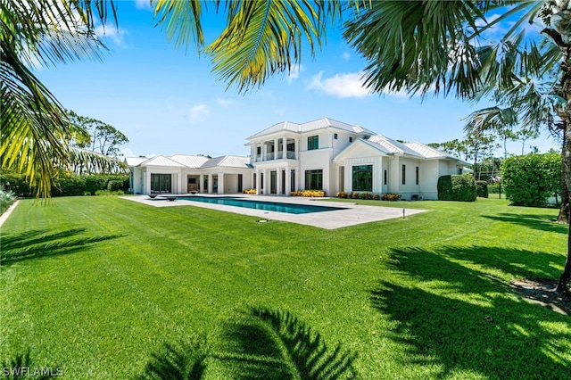 rear view of house featuring a patio and a lawn