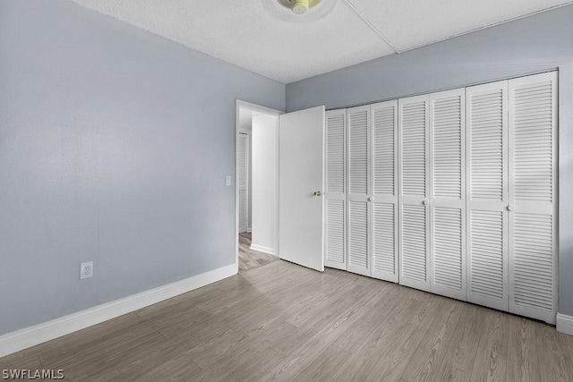 unfurnished bedroom featuring light hardwood / wood-style floors and a closet