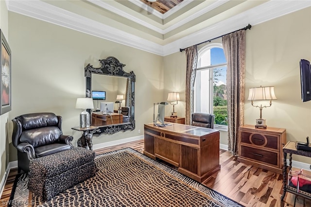 home office with ornamental molding, a raised ceiling, hardwood / wood-style floors, and a wealth of natural light