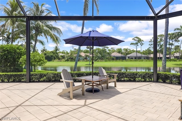 view of patio / terrace with a water view and a lanai