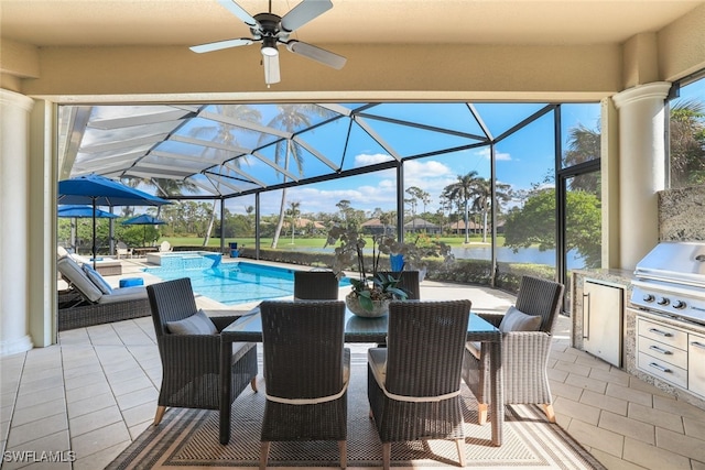 view of pool featuring a lanai, a water view, a patio area, area for grilling, and exterior kitchen