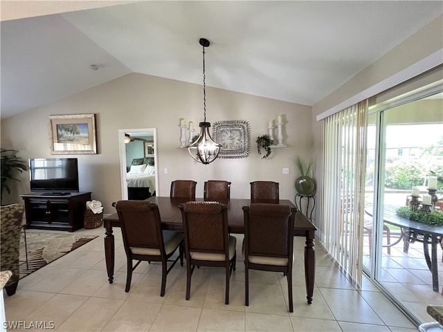 tiled dining space with lofted ceiling and a chandelier