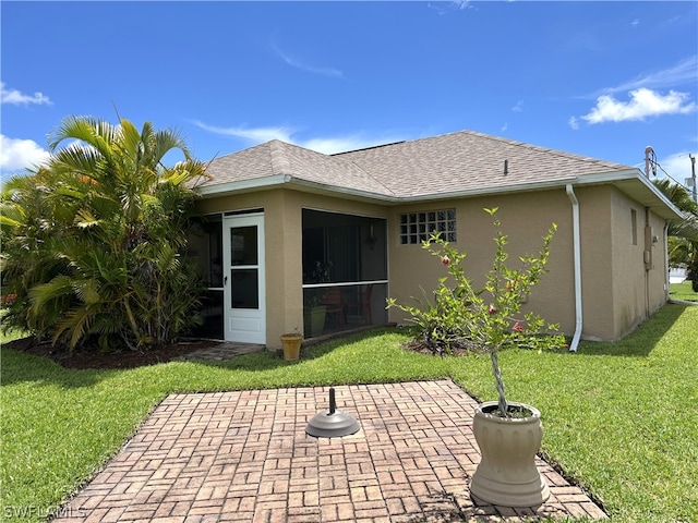 rear view of property featuring a patio and a lawn