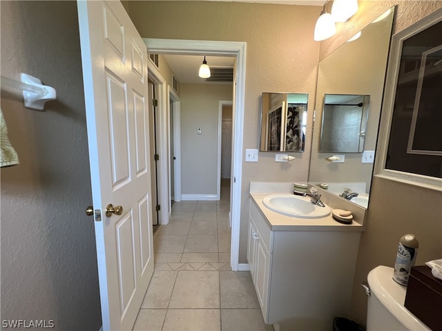 bathroom featuring tile floors, oversized vanity, and toilet