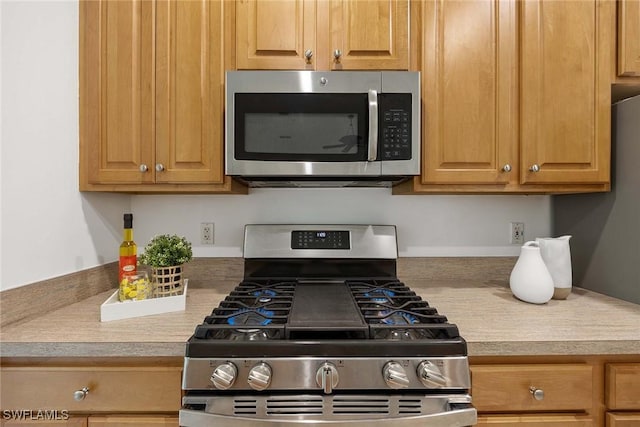 1732 Tarpon Bay Dr S Unit 203, Naples, FL 34119 - kitchen with appliances with stainless steel finishes and light countertops