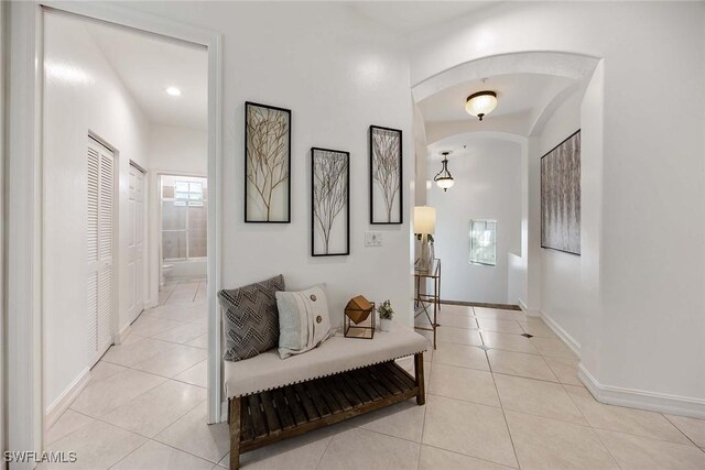 1732 Tarpon Bay Dr S Unit 203, Naples, FL 34119 - hallway with tile patterned floors, arched walkways, and baseboards