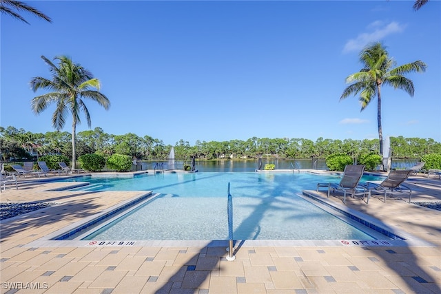 view of pool with a water view and a patio