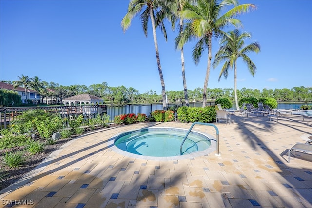 view of swimming pool with a patio, a water view, and a community hot tub