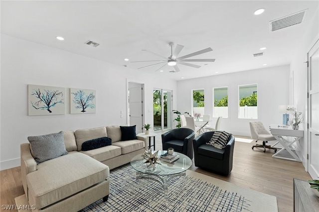 living room with ceiling fan and light hardwood / wood-style flooring