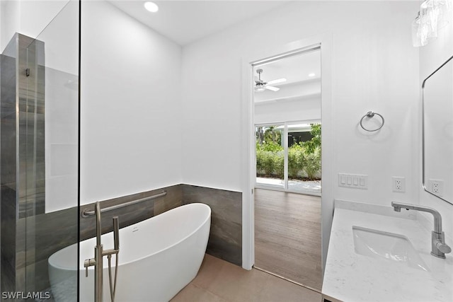 bathroom featuring tile patterned flooring, vanity, tile walls, and shower with separate bathtub