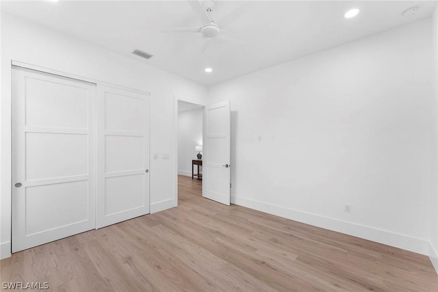 unfurnished bedroom with a closet, light hardwood / wood-style flooring, and ceiling fan