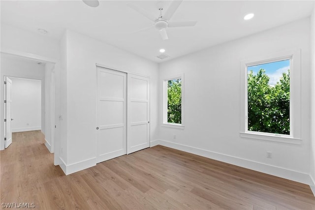 unfurnished bedroom with a closet, light hardwood / wood-style flooring, and ceiling fan