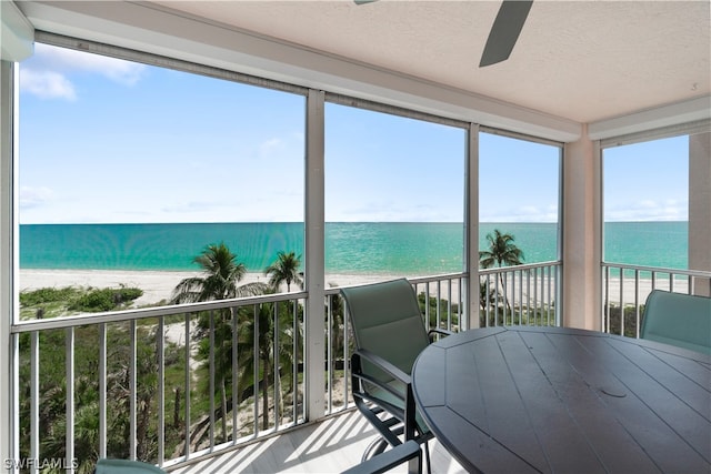 sunroom / solarium with a view of the beach and a water view