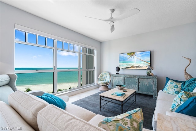 living room featuring a water view, a healthy amount of sunlight, and ceiling fan