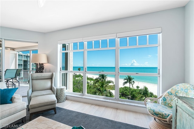 living room featuring a water view, hardwood / wood-style flooring, and a healthy amount of sunlight