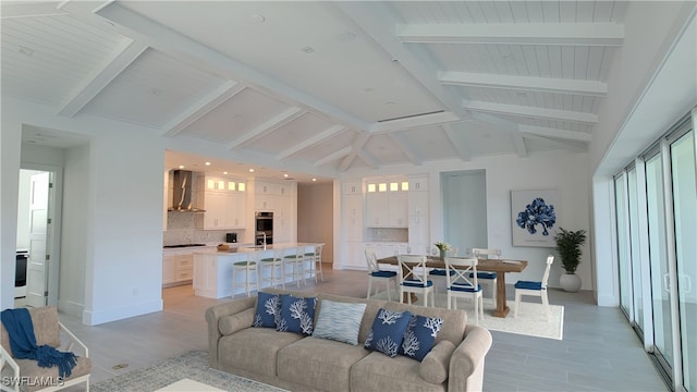 living room featuring light hardwood / wood-style floors and lofted ceiling with beams