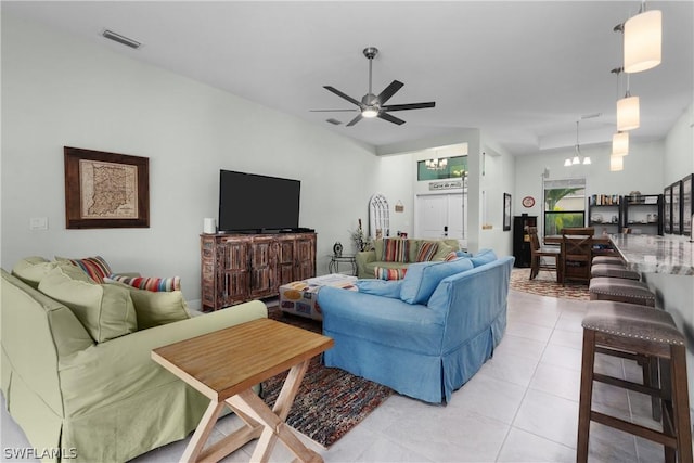 living room with ceiling fan with notable chandelier and light tile patterned floors