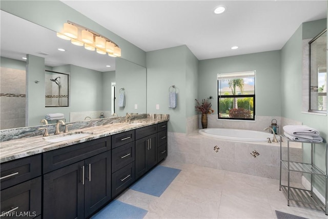 bathroom with tile patterned floors, vanity, and shower with separate bathtub