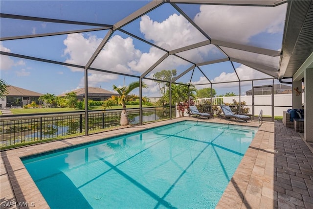 view of swimming pool featuring a water view, glass enclosure, and a patio area