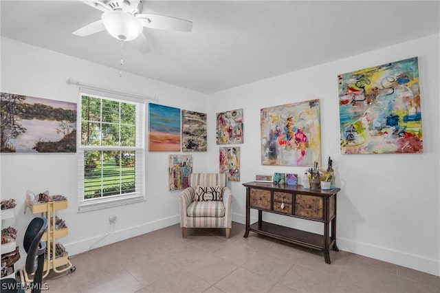 living area featuring light tile patterned floors, ceiling fan, and a healthy amount of sunlight