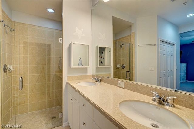 bathroom with vanity and a shower with door