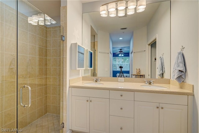 bathroom with vanity, a shower with shower door, and ceiling fan